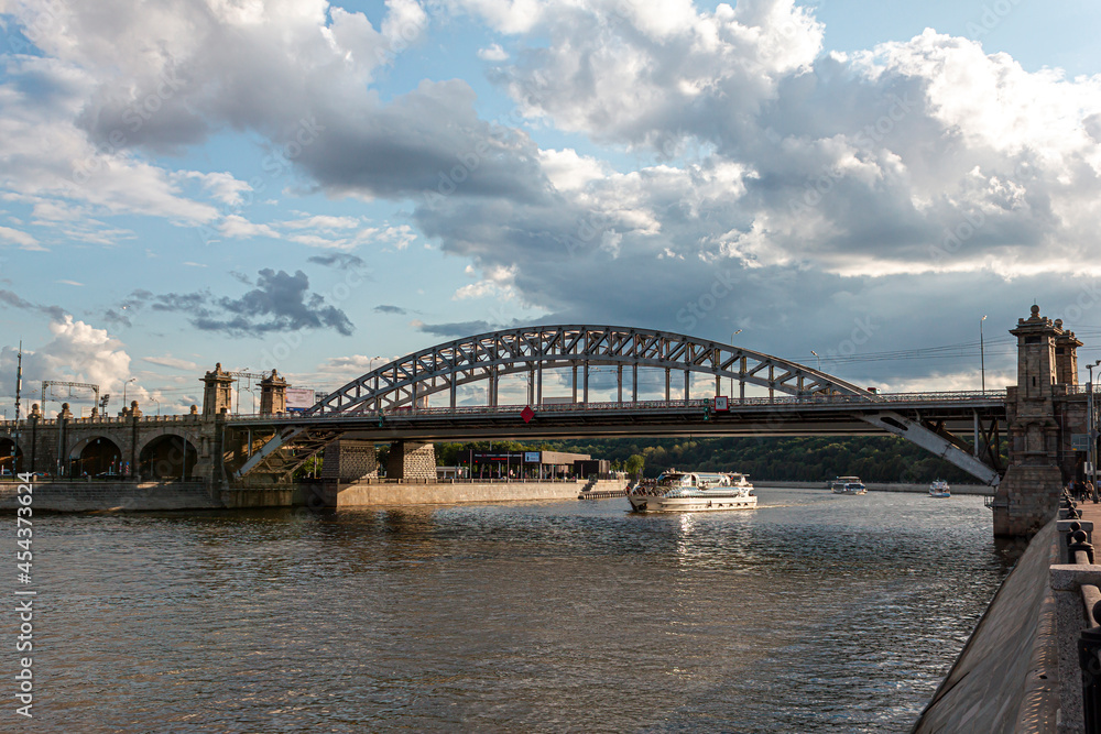 River cruise ship sails under the bridge