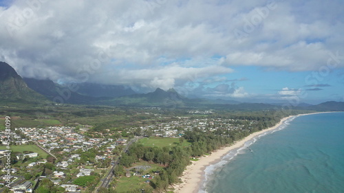 Colorful aerial view of rocky mountains. A tropical beach with turquoise blue ocean water and waves lapping on a hidden white sandy beach. Waimanalo Beach, Oahu Island, Hawaii.