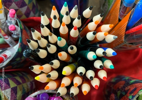 A collection of colorful pens on a glass