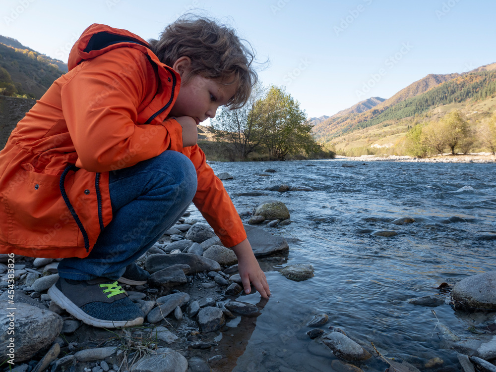 The teenager boy on mountain river beach The teenager boy on mountain river beach