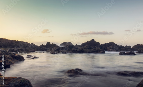 long exposure photo of the sea water between the rocks in the evening light