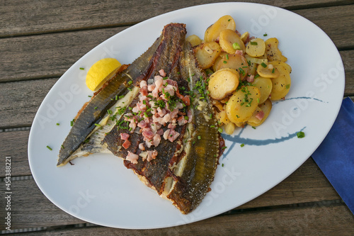 Fotografia Freshly fried whole plaice from the Baltic Sea with bacon, fried potatoes and ch