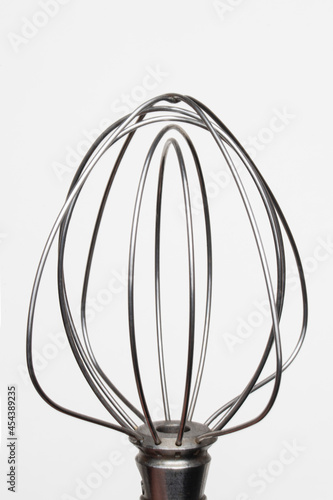 Stainless steel electric mixer beater on a white background