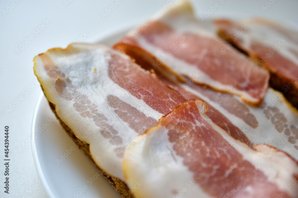 Fresh juicy bacon on a piece of rye bread Fresh juicy bacon on a piece of rye bread