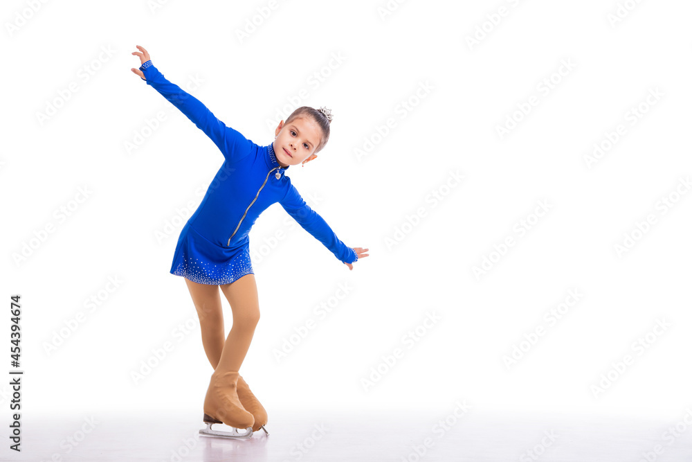 A Little young figure skater posing in blue training dress on ice on white background A Little young figure skater posing in blue training dress on ice on white background