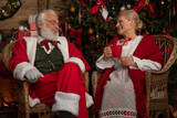 Santa Claus and wife Mrs. Claus near fireplace
