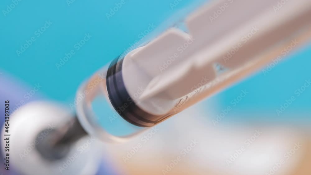 Doctor in a surgical gloves filling a syringe from vial with vaccine against Covid-19 or Flu, bottle with antibiotic treatment injection. Medicines concept Doctor in a surgical gloves filling a syringe from vial with vaccine against Covid-19 or Flu, bottle with antibiotic treatment injection. Medicines concept