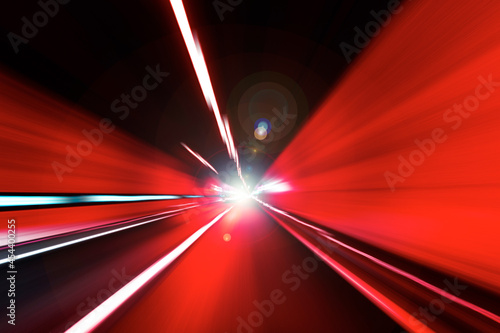 Cars rush through the tunnel in the beams of searchlights. Motion effect.