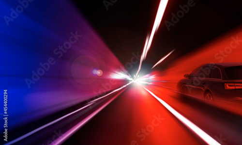 Cars rush through the tunnel in the beams of searchlights. Motion effect.