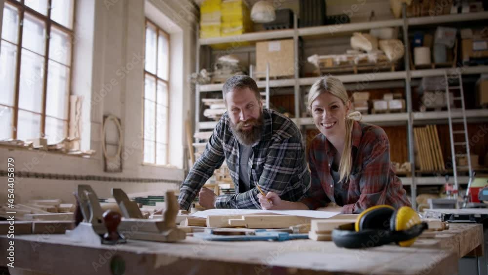 Two carpenters talking about design of products, looking at camera. Small business concept. Two carpenters talking about design of products, looking at camera. Small business concept.