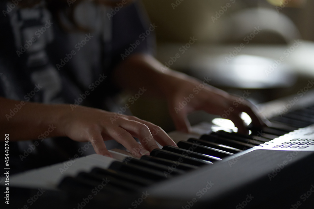 The musician's hands on the synthesizer. A cropped image of a person playing a synthesizer. Side view. High quality photo The musician's hands on the synthesizer. A cropped image of a person playing a synthesizer. Side view. High quality photo
