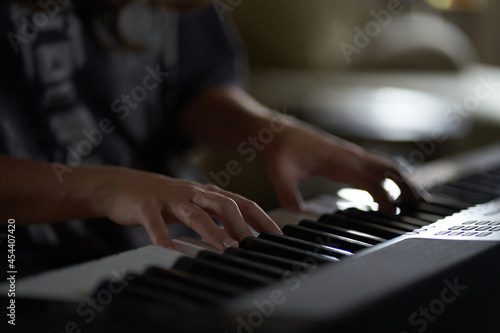 The musician's hands on the synthesizer. A cropped image of a person playing a synthesizer. Side view. High quality photo
