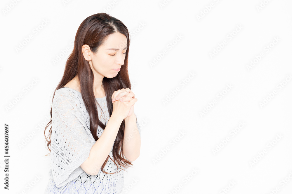 手を合わせてお願いするカジュアルな服を着た女性 手を合わせてお願いするカジュアルな服を着た女性