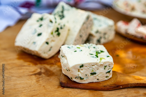 Slice of sheep cheese on a wooden background made from homemade fresh milk.