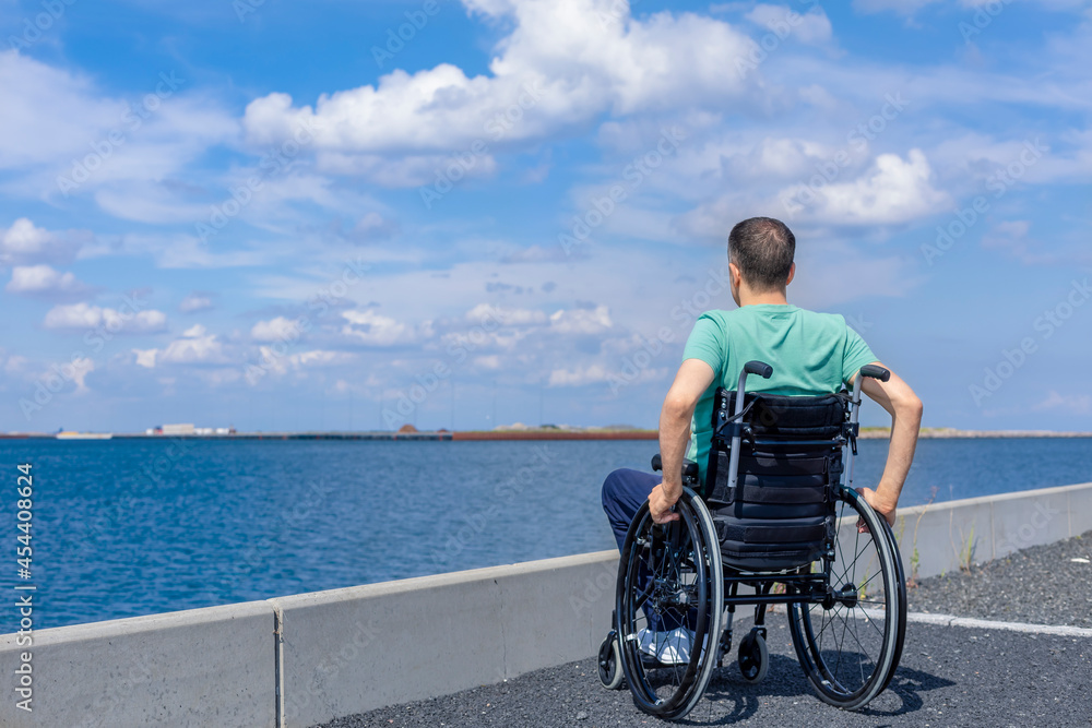 Disabled man in a wheelchair at the sea. Travel, mobility and freedom concept. Disabled man in a wheelchair at the sea. Travel, mobility and freedom concept.
