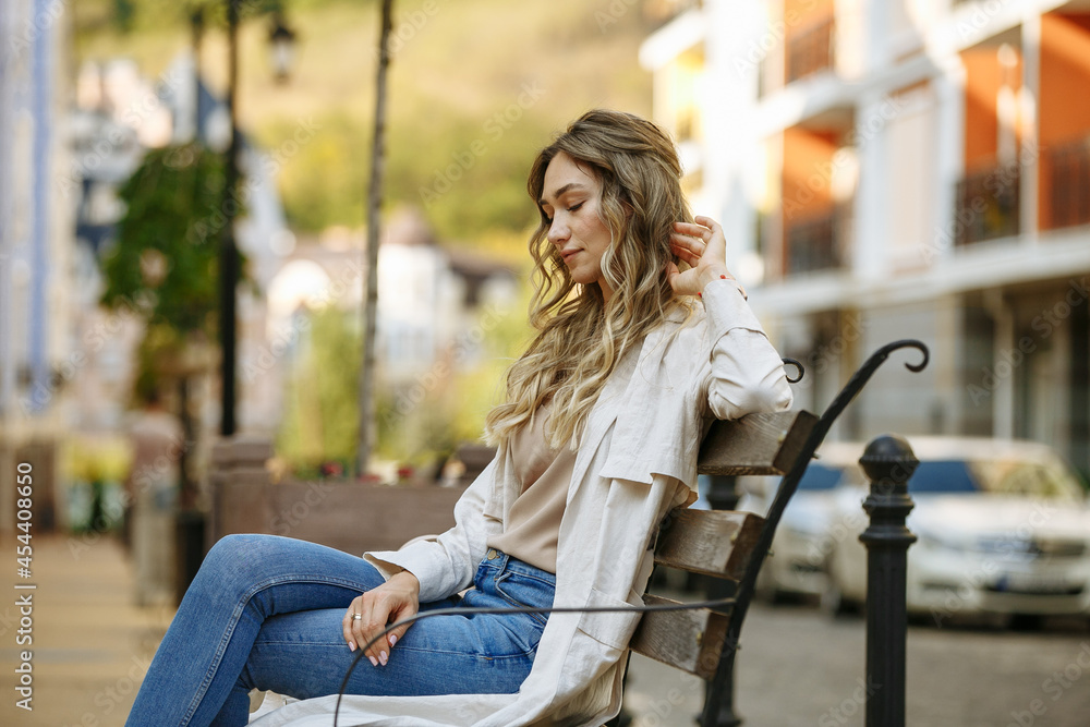woman sitting on a bench against the background of the city