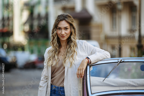 woman in palshche posing against the background of a retro car