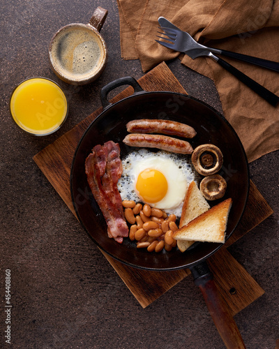 Wallpaper Mural Vertical flat lay of classic english fat breakfast with fried eggs, ham, grilled sausages, kidney beans, mushrooms, toast, hot coffee and fresh orange juice. Pan fried delicious nutritious cuisine Torontodigital.ca