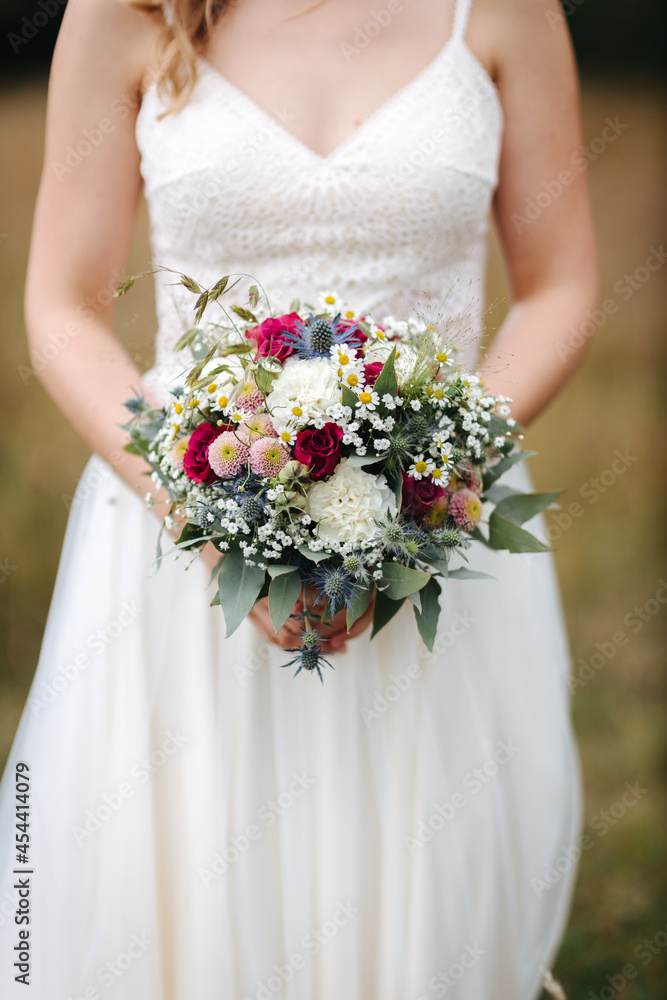 Bride holding beautiful wedding bouquet in her hands close-up Bride holding beautiful wedding bouquet in her hands close-up