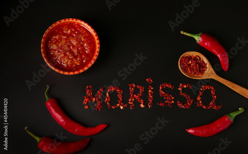 Hot sauce paste harissa with chili pepper on dark background, Tunisia and Arabic cuisine, word Harissa of Dry pepper, Top view. photo