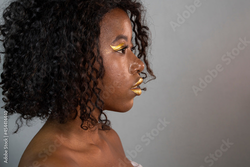 portrait of beautiful african woman with creative gold make up