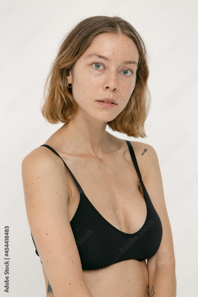 Beautiful girl without makeup with natural skin in lingerie on a white background Beautiful girl without makeup with natural skin in lingerie on a white background
