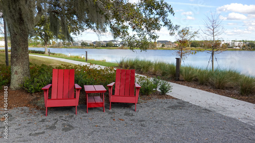 Two chairs sitting in a park by a lake in Laurete Park in Lake Nona, Orlando, FL on a beautiful sunny day. photo