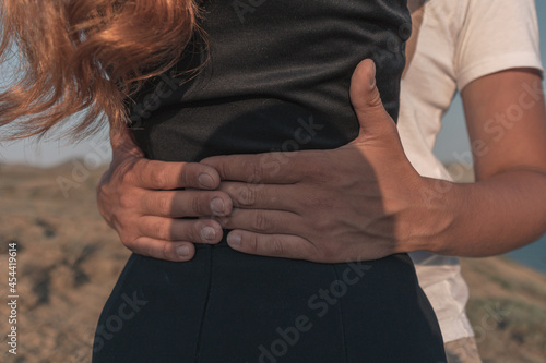 A man hugs a girl around the waist. A couple in love