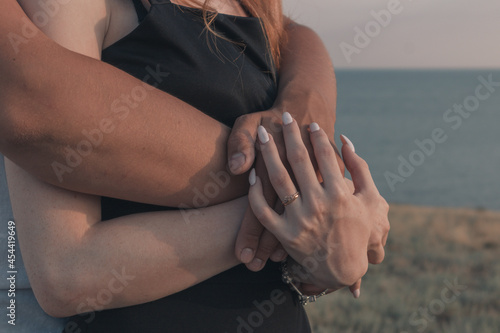 A boy and a girl in love hugging at sunset.