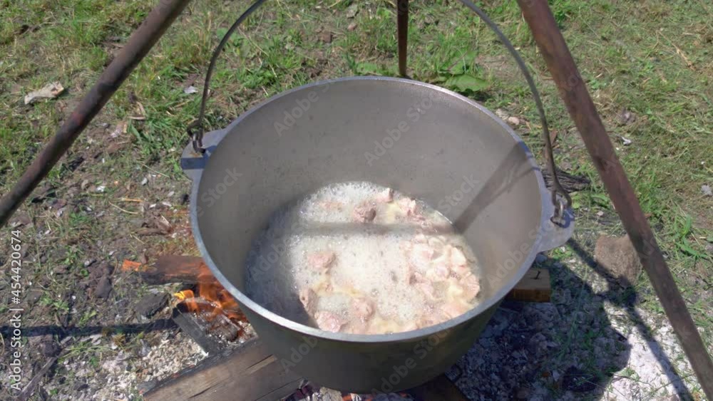 Meat is boiling in a pot outdoors cooking slow motion Meat is boiling in a pot outdoors cooking slow motion