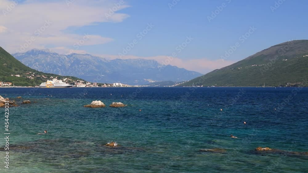 Transparent clear water splashes on an ecologically clean summer beach in Herceg Novi, Montenegro. Holidays, travel and tourism in the Bay Kotor, Adriatic Sea in Montenegro Transparent clear water splashes on an ecologically clean summer beach in Herceg Novi, Montenegro. Holidays, travel and tourism in the Bay Kotor, Adriatic Sea in Montenegro
