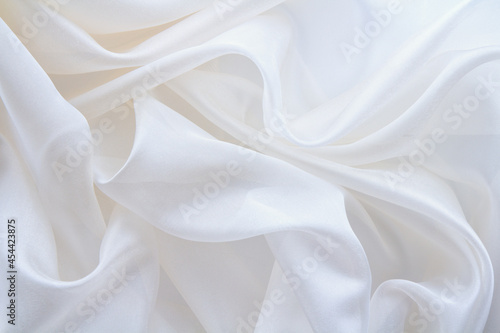diaphanous white fabric draped with folds, textile wave background