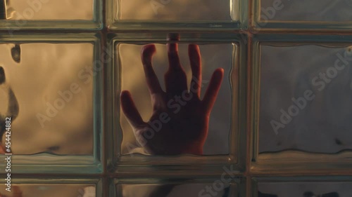 hand touching window behind glass creepy stalker concept photo
