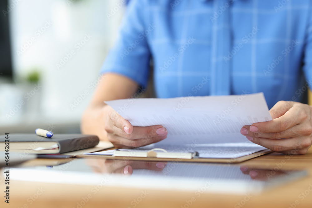 Businesswoman examines financial documents with business reports closeup Businesswoman examines financial documents with business reports closeup