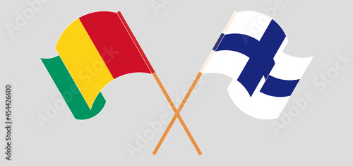 Crossed and waving flags of Guinea and Finland