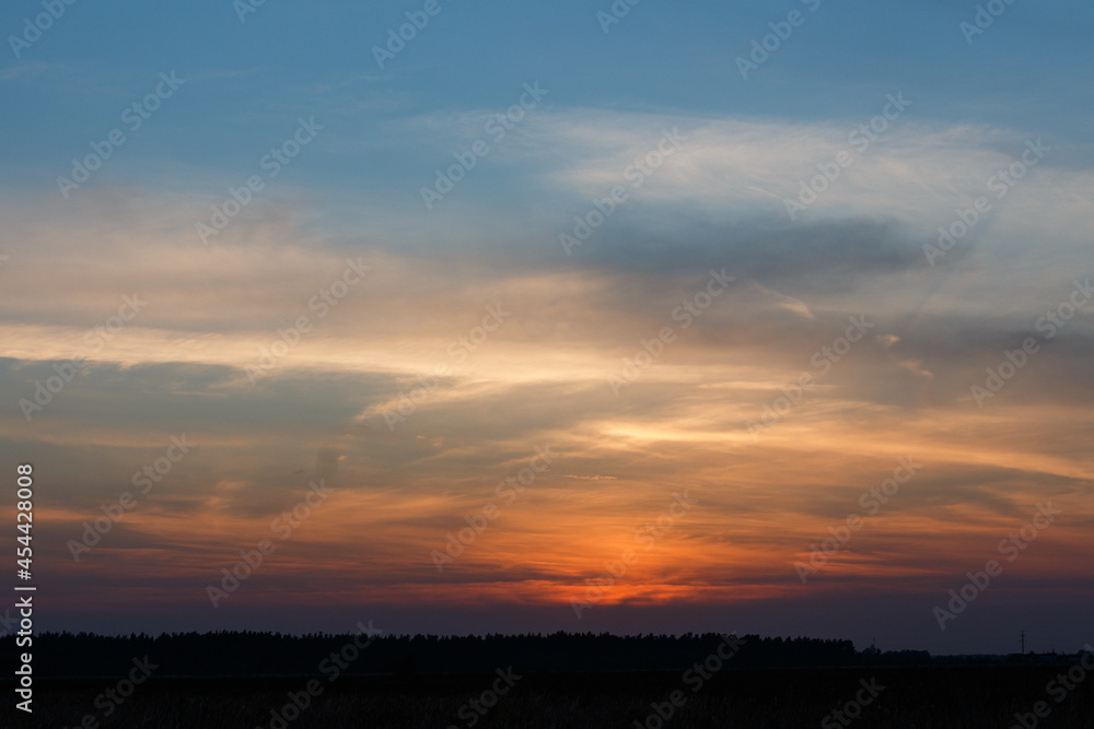 Sunset inMoscow oblast, Russia. Blue clouds. Orange sun strip.