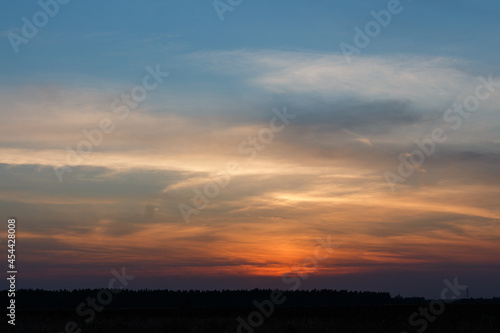 Sunset inMoscow oblast, Russia. Blue clouds. Orange sun strip. © olegkliucharev