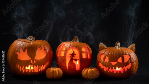 Illuminated jack o lantern halloween pumpkins, on black background 