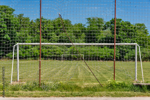Soccer goal with net in rural field with grass