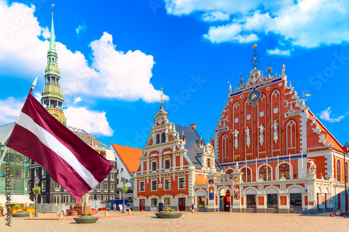 View of the Old Town Ratslaukums square, Roland Statue, The Blackheads House and St Peters Cathedral against blue sky in Riga, Latvia. Summer sunny day photo