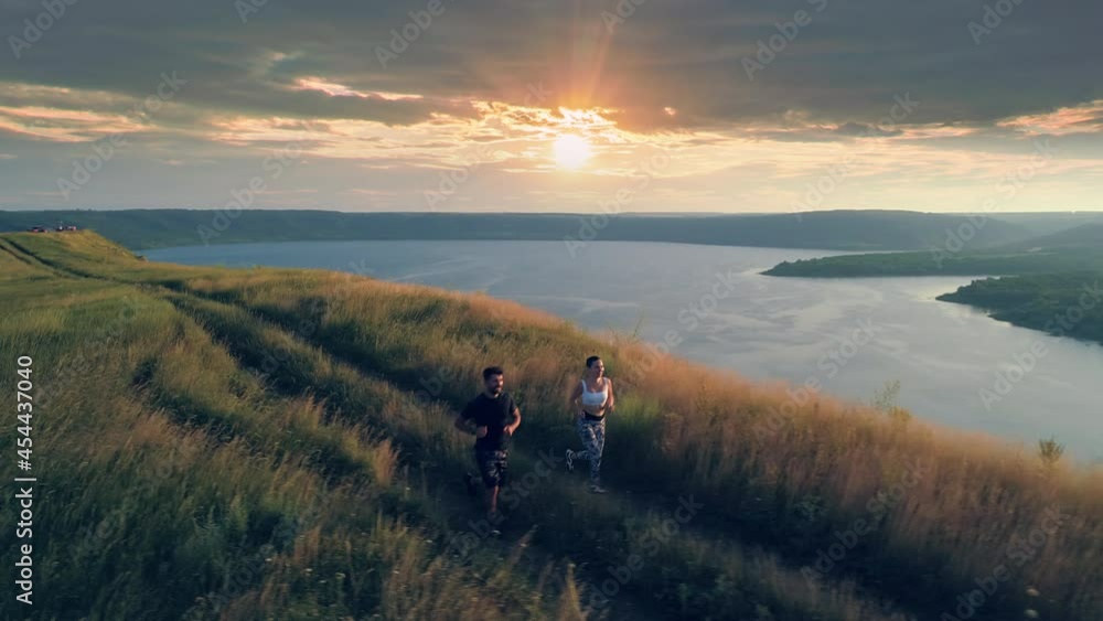 The young couple jogging on the beautiful river background. slow motion The young couple jogging on the beautiful river background. slow motion