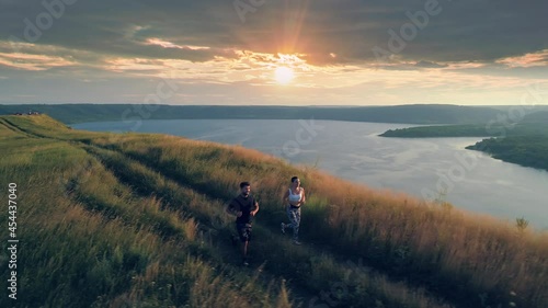 The young couple jogging on the beautiful river background. slow motion