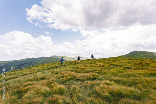 mountain hiking concept. vacation in the mountains. three people walking on top of a mountain photo