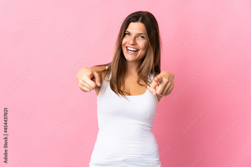 Young slovak woman isolated on pink background surprised and pointing front Young slovak woman isolated on pink background surprised and pointing front
