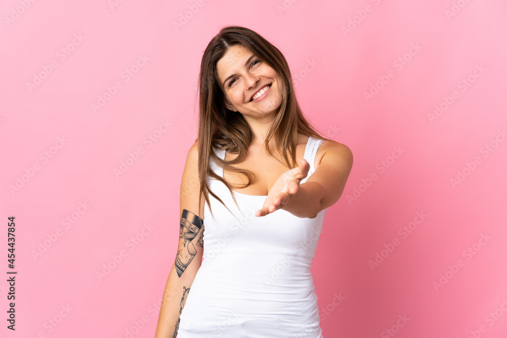 Young slovak woman isolated on pink background shaking hands for closing a good deal Young slovak woman isolated on pink background shaking hands for closing a good deal
