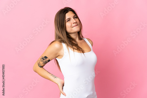 Young slovak woman isolated on pink background suffering from backache for having made an effort