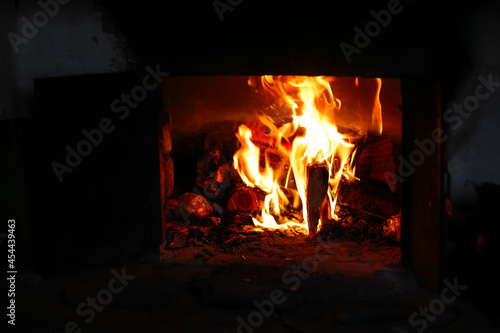 Defocus fire flame background. Firewood burning in old stove or oven. Dark and black. Orange flame. Heat energy. Open iron door. Out of focus