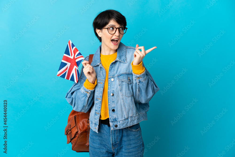 Woman holding an United Kingdom flag over isolated background intending to realizes the solution while lifting a finger up Woman holding an United Kingdom flag over isolated background intending to realizes the solution while lifting a finger up