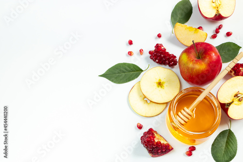 Concept of traditional Jewish holiday of Rosh Hashanah. New Year. Pomegranates, honey and apples on white background. Place for your text.