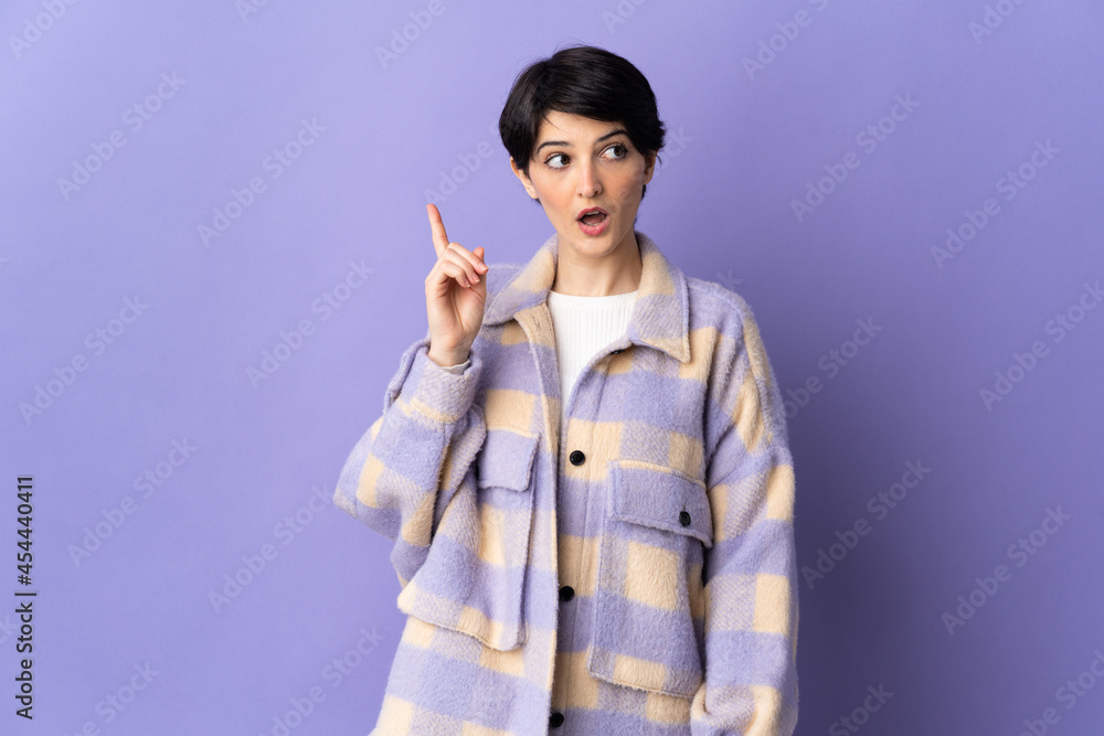 Woman with short hair isolated on purple background thinking an idea pointing the finger up Woman with short hair isolated on purple background thinking an idea pointing the finger up